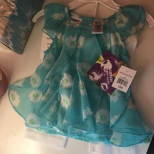 Blue flowy top with white Capri length pants